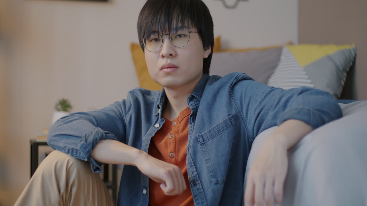 Young Man Sitting in a Bedroom