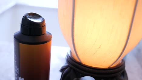 man picks up can of deoderant spray from bathroom vanity top