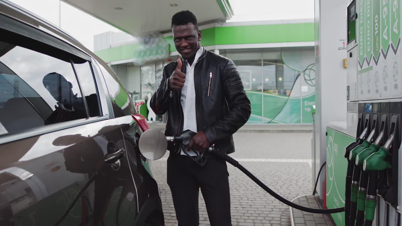 Un uomo scende dall'auto alla stazione di servizio per fare benzina
