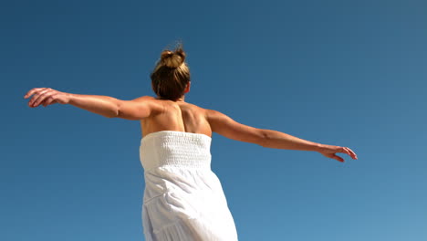 Carefree-blonde-spinning-around-on-sunny-day