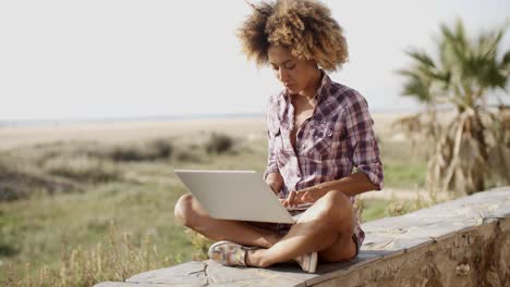 chica trabajando con una computadora portátil al aire libre