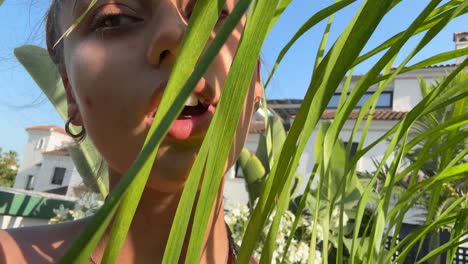 woman hiding behind palm leaves