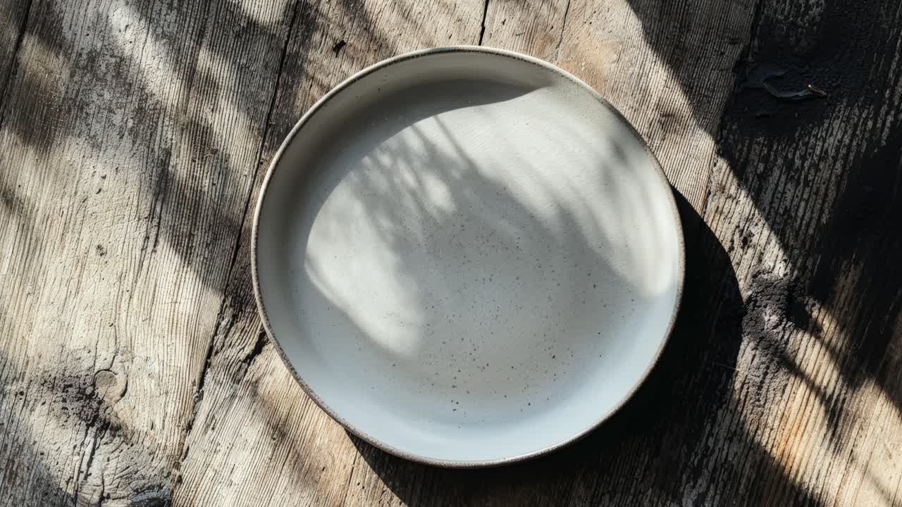 Empty white plate on a wooden table
