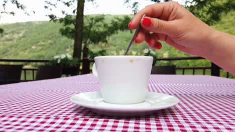 café de dirección de mano femenina en la textura de la mantella de mesa a cuadros clásica roja