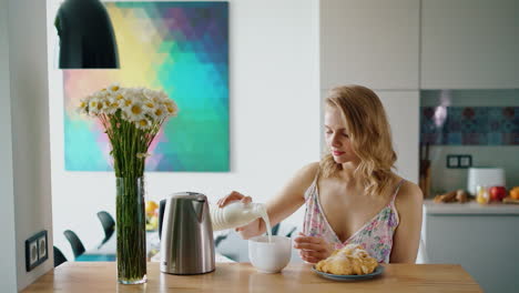 hermosa chica preparando café con leche. mujer vertiendo leche en el café