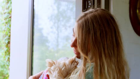 Woman-holding-her-dog-at-home-4k