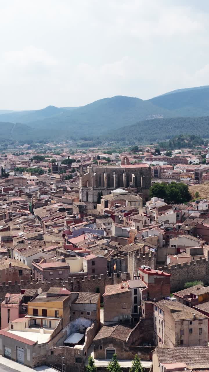 Vista aérea de un pueblo europeo con montañas al fondo