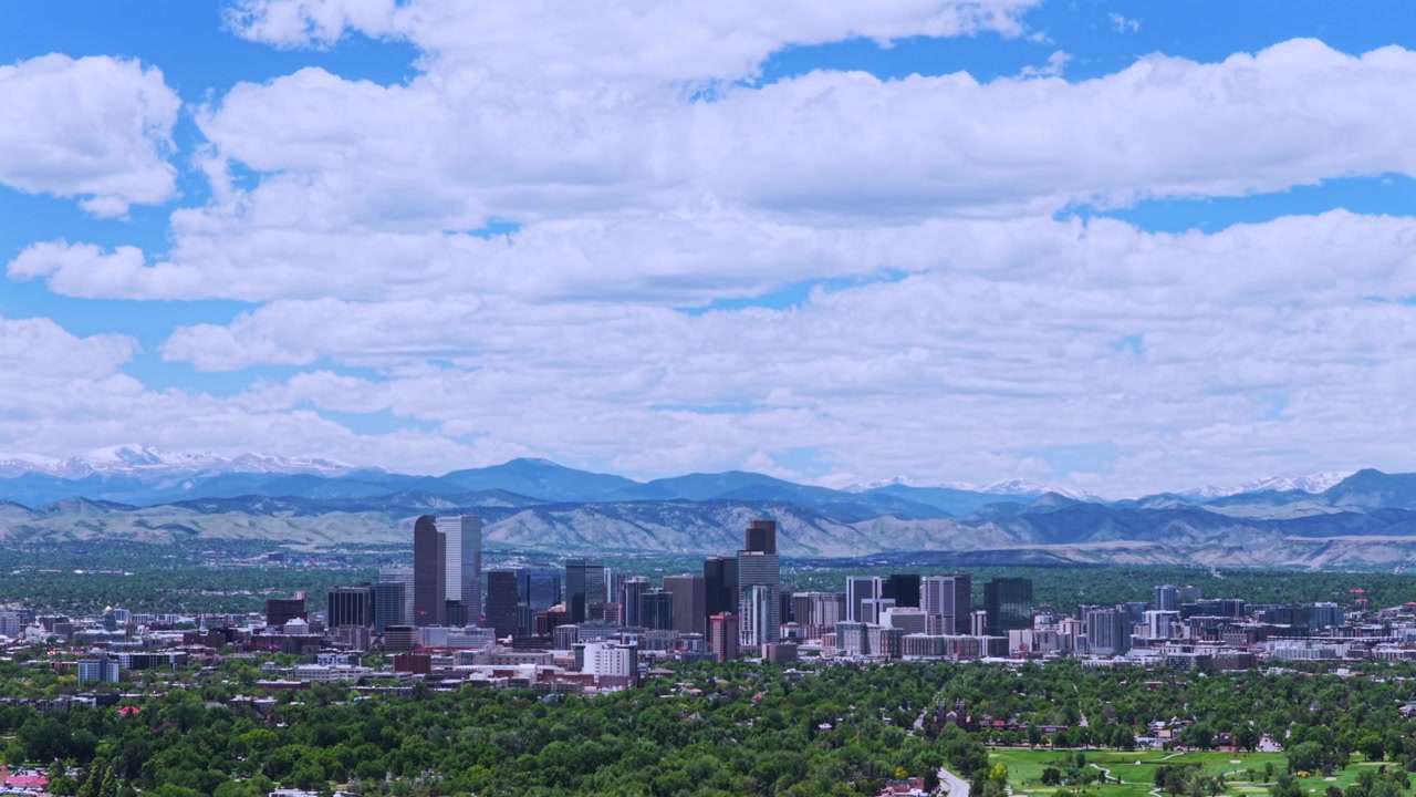 Downtown Denver, Colorado, droneoptagelse af City Park Golf Course, Front Range, sneklædte Rocky Mountains, forårsbybillede, skyline, skyskrabere, landskab, morgen, blå himmel, skyer, cirkler til venstre.