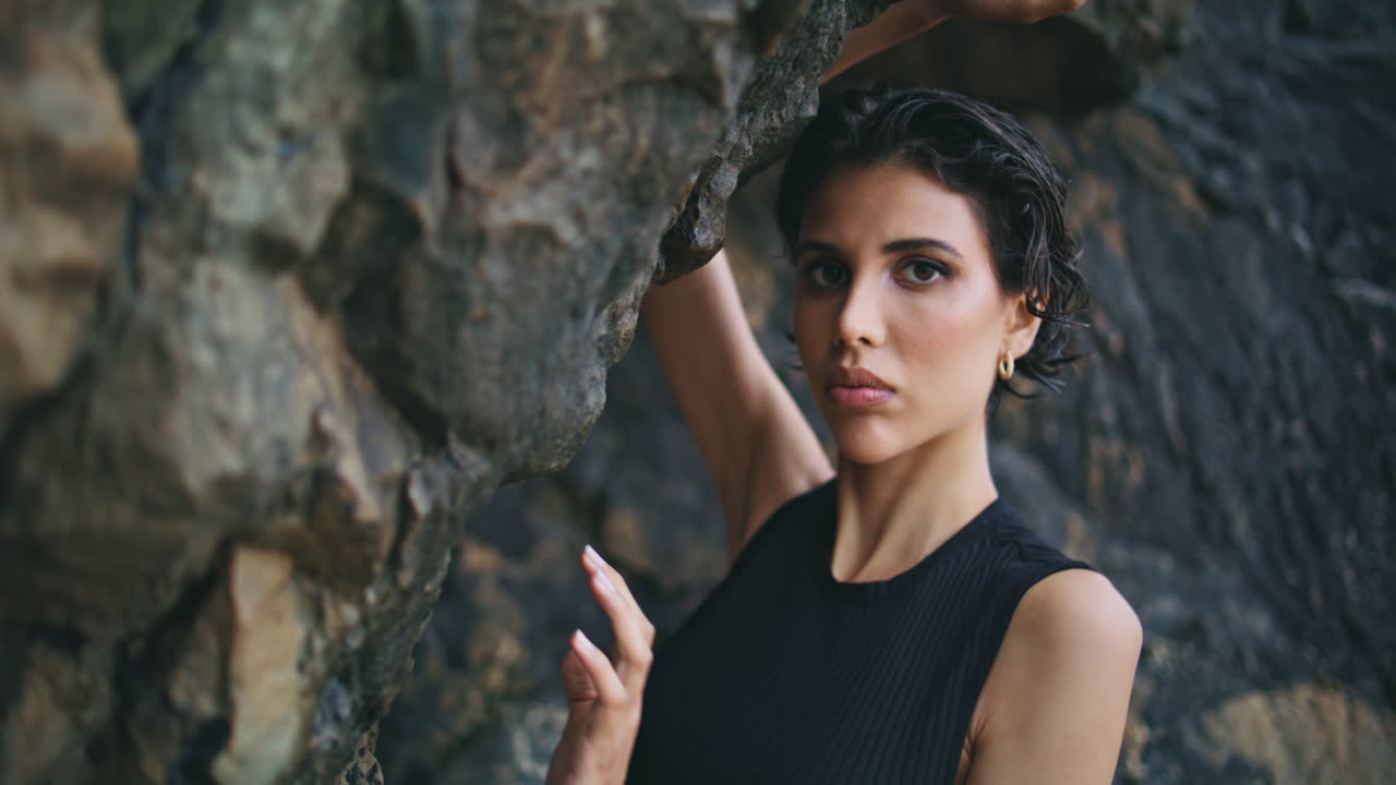 una mujer de moda posando en un retrato de la orilla de los acantilados.