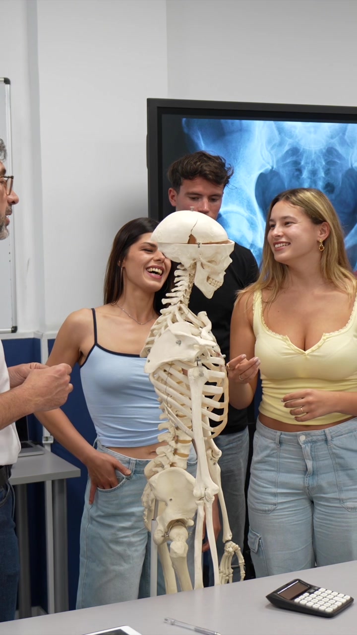 Professor Explaining Human Anatomy to Students Using a Skeleton Model