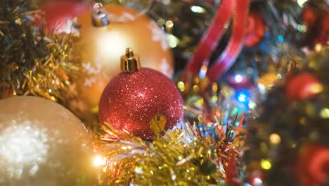 hand placing a red ornament among christmas decorations