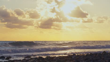 Sonnenuntergang-Am-Felsigen-Strand-Mit-Der-Sonne-Hinter-Den-Wolken