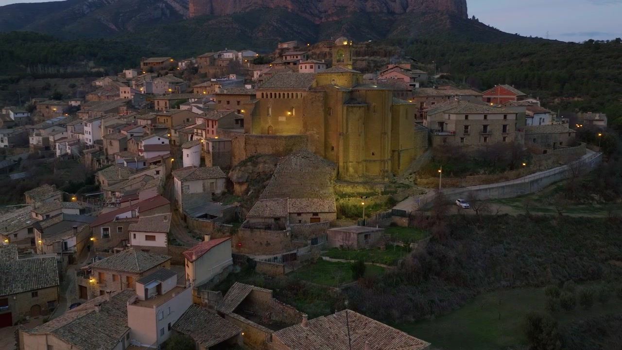 Iglesia iluminada en el corazón de un pueblo medieval español al anochecer