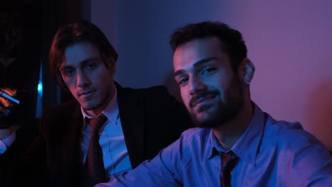 two man smiles on purple background