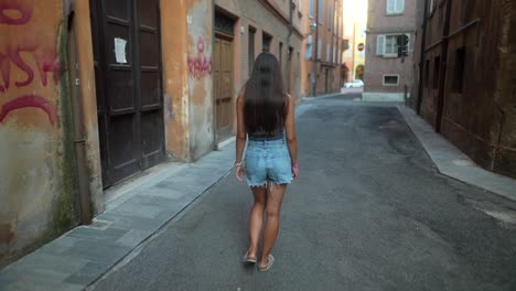 mujer caminando por un estrecho callejón italiano