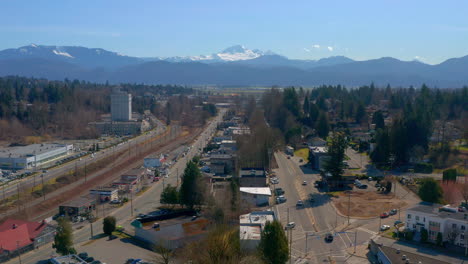 flying above a scenic mountain town near mt baker as cars pass on the streets below