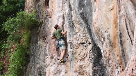 person climbing a steep rock face