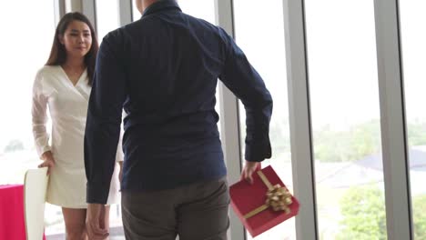 romantic couple giving gift to lover at restaurant