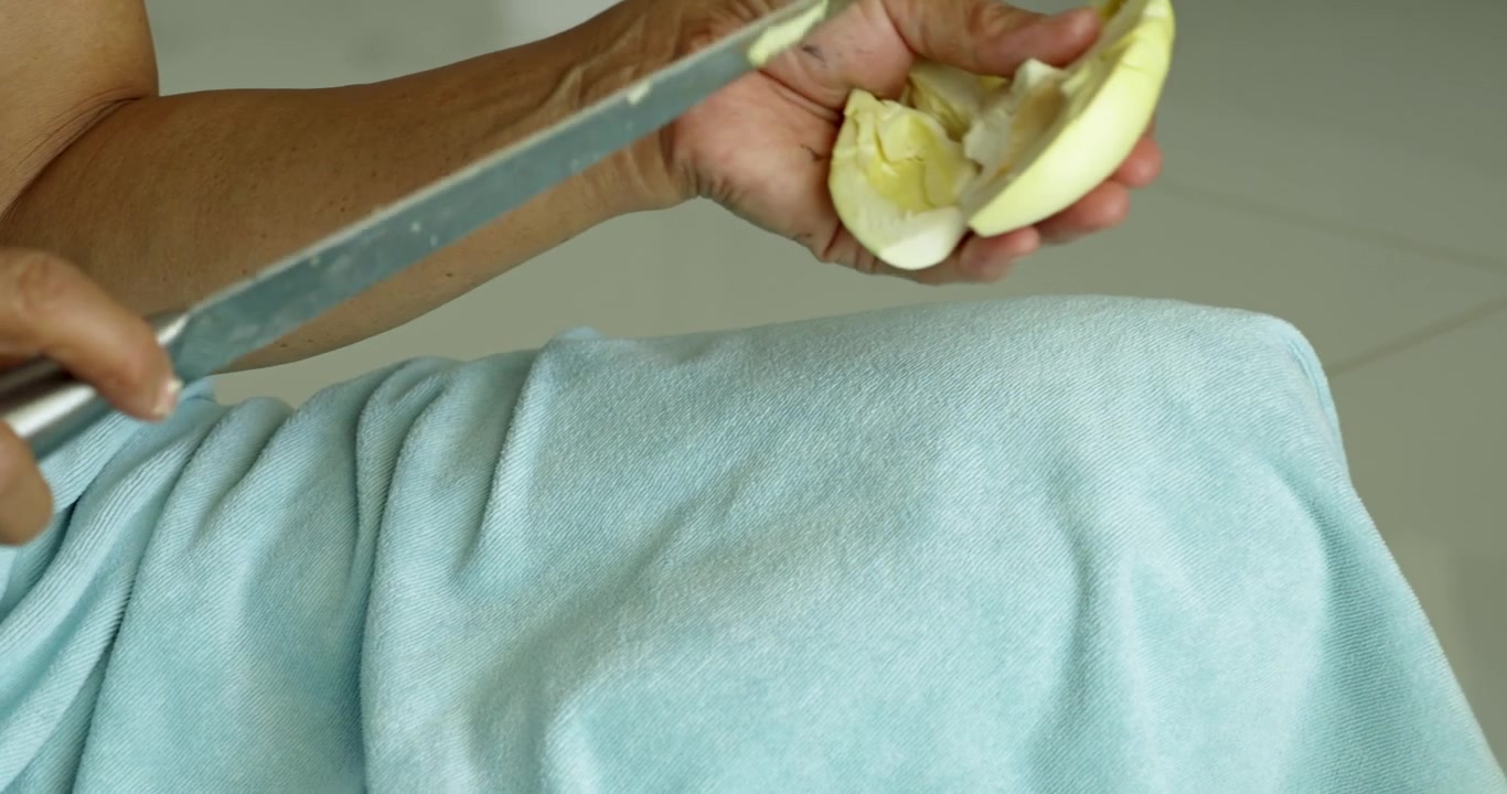 Witness delicate process of preparing durian fruit in a cozy home kitchen setting.
