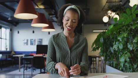 portrait of happy african american businesswoman talking and looking at camera at office
