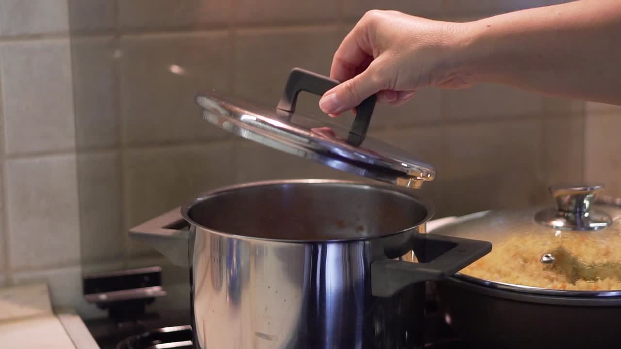 Taking of the pot lid and steam comes out of it