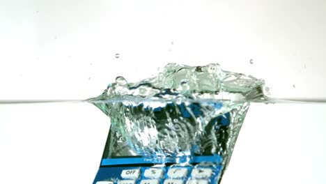 blue calculator falling into water