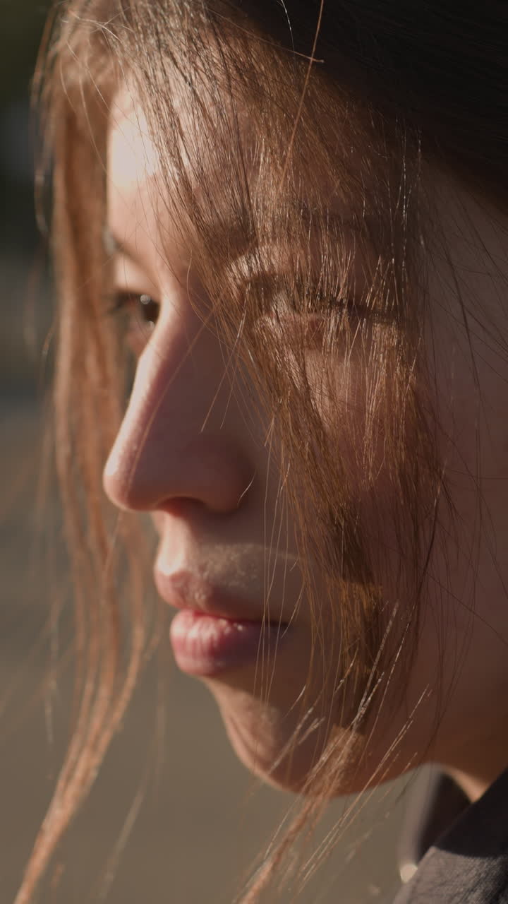 Close-up of a depressed girl with her hair partially covering her face. She appears sad and lost in thought, her expression reflecting deep melancholy and introspection