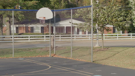 View-of-a-basketball-net-and-backboard-outside-on-a-school-blacktop-on-a-sunny-day