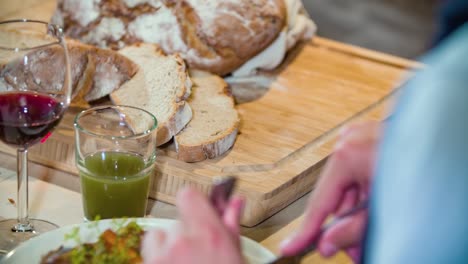 slow motion of slices of bread and a man eating a slovenian meal with meat, vegetables and herbs