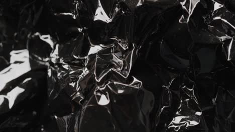 Close-up-of-black-crumpled-plastic-rubbish-bag-in-slow-motion