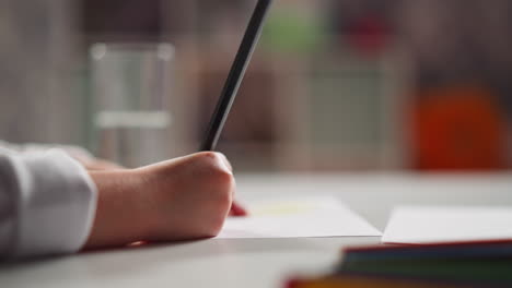 little student draws picture and drinks water at art lesson