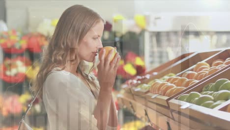 animation of financial data over happy caucasian woman shopping at market, picking orange