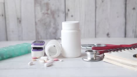 pulse oximeter, medical pills and blister pack on table