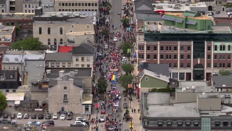 Toma-Aérea-De-La-Ciudad-De-Personas-Celebrando-El-Día-Del-Orgullo-Con-Un-Desfile