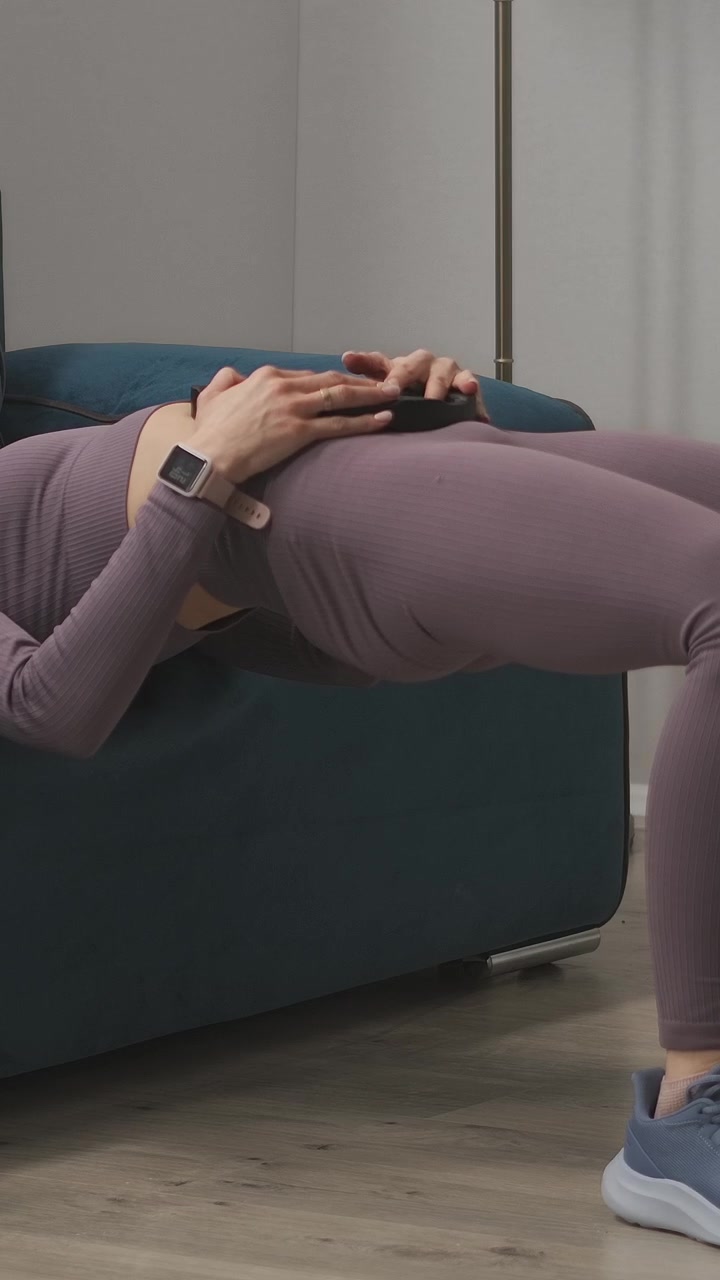Young Woman Performing Hip Thrusts with Weight Plate at Home