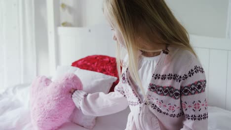 girl holding heart shape cushion 4k