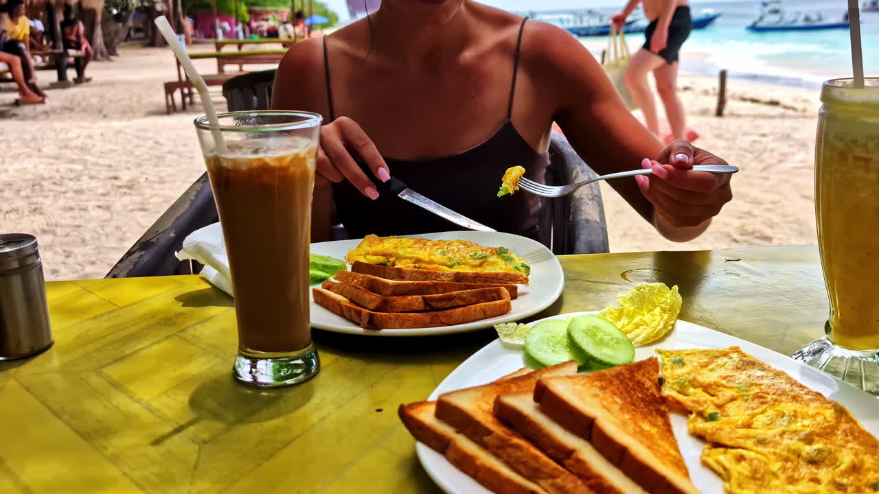A person enjoys a simple breakfast of toast and eggs in the calm beauty of Gili Meno island