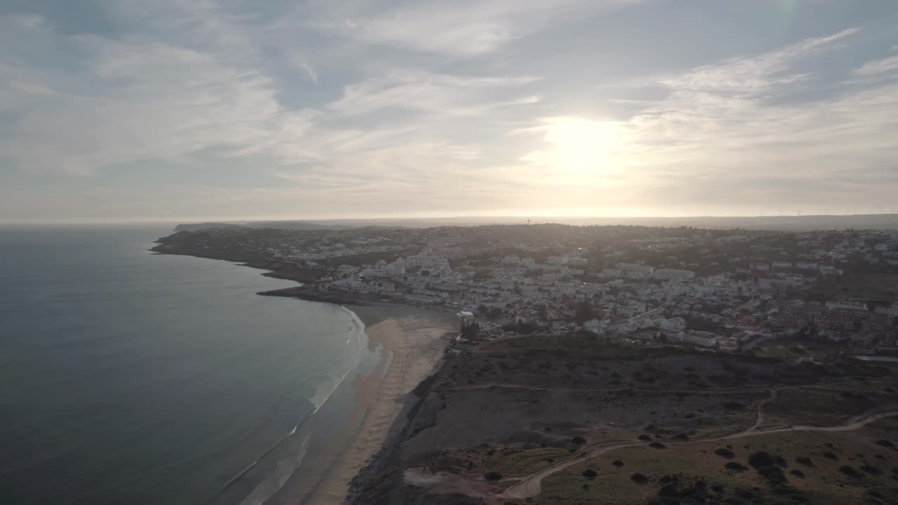 Praia da Luz resort town overlooking calm Atlantic Ocean at sunset. Beach holidays concept