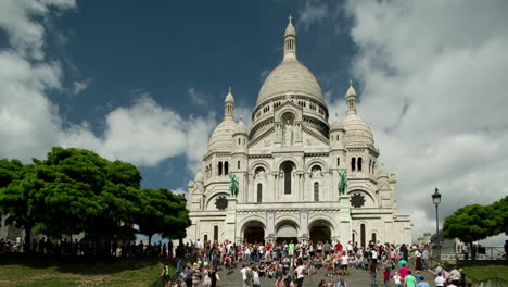 sacre coeur cathedral in paris with tourists on the steps