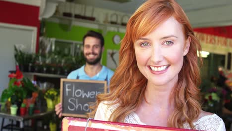 Florists-holding-signboards-in-flower-shop