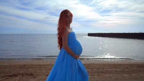 pregnant woman in blue dress flying on wind. pregnancy concept