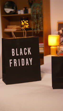 black friday shopping bags on a bed