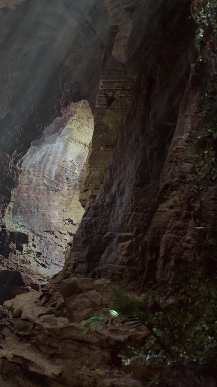 La luce filtra attraverso una grotta in montagna durante il giorno.