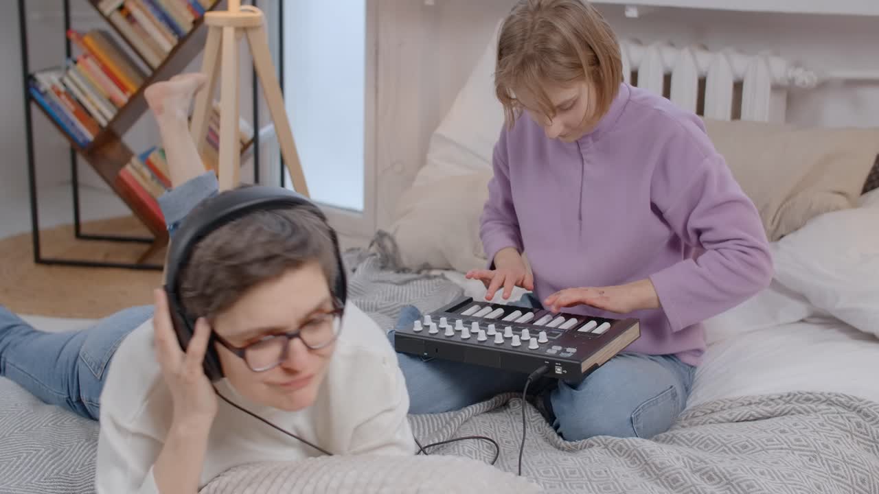 Two girls making music in a bedroom