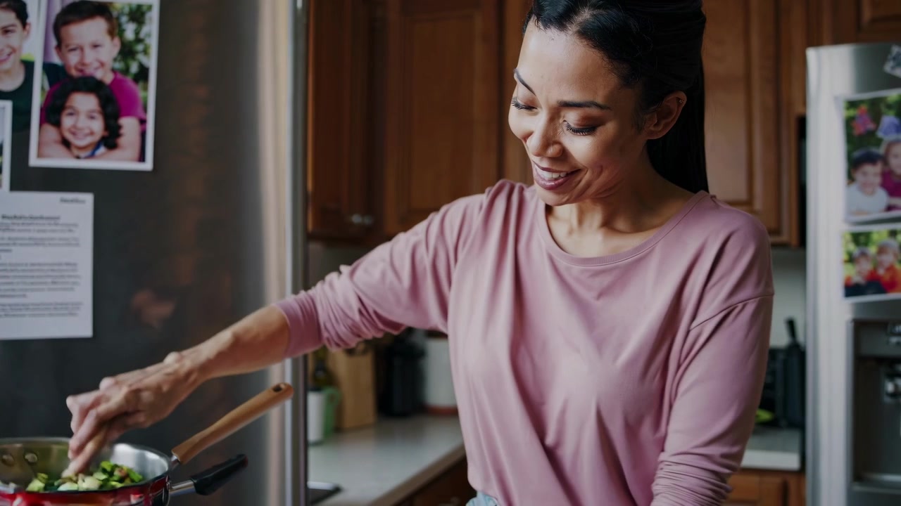 Mulher sorridente cozinhando vegetais em uma cozinha doméstica
