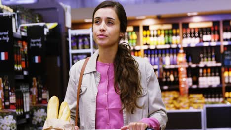 mujer caminando con un carrito de compras en la sección de comestibles
