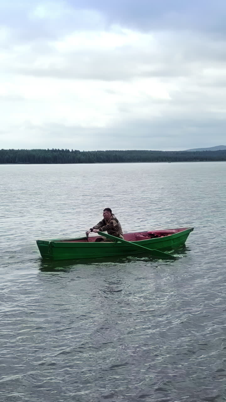 hombre remando un barco en un lago
