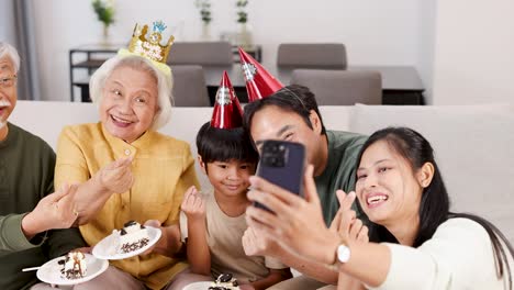 a joyful family captures moments with cake and selfies in a bright, festive living room setting