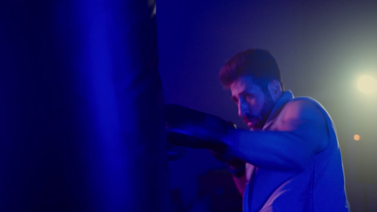 Man Training in Boxing Gym with Colored Lights