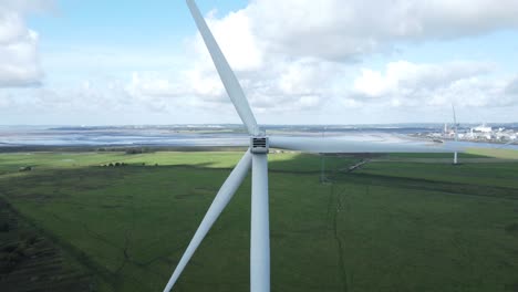 alternative green energy wind farm turbines spinning in frodsham cheshire fields aerial view closeup pull back